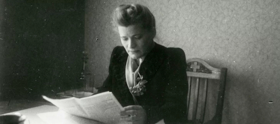 Herta Hanzena sitting and reading a newspaper
