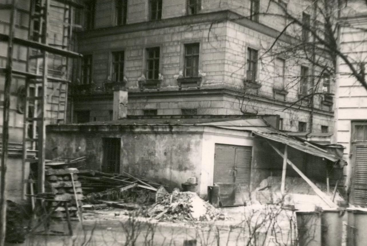 Photo from the construction process of the building. It shows stairs and various construction debris on the ground, as well as partially visible elevation structures along the facade of the building.