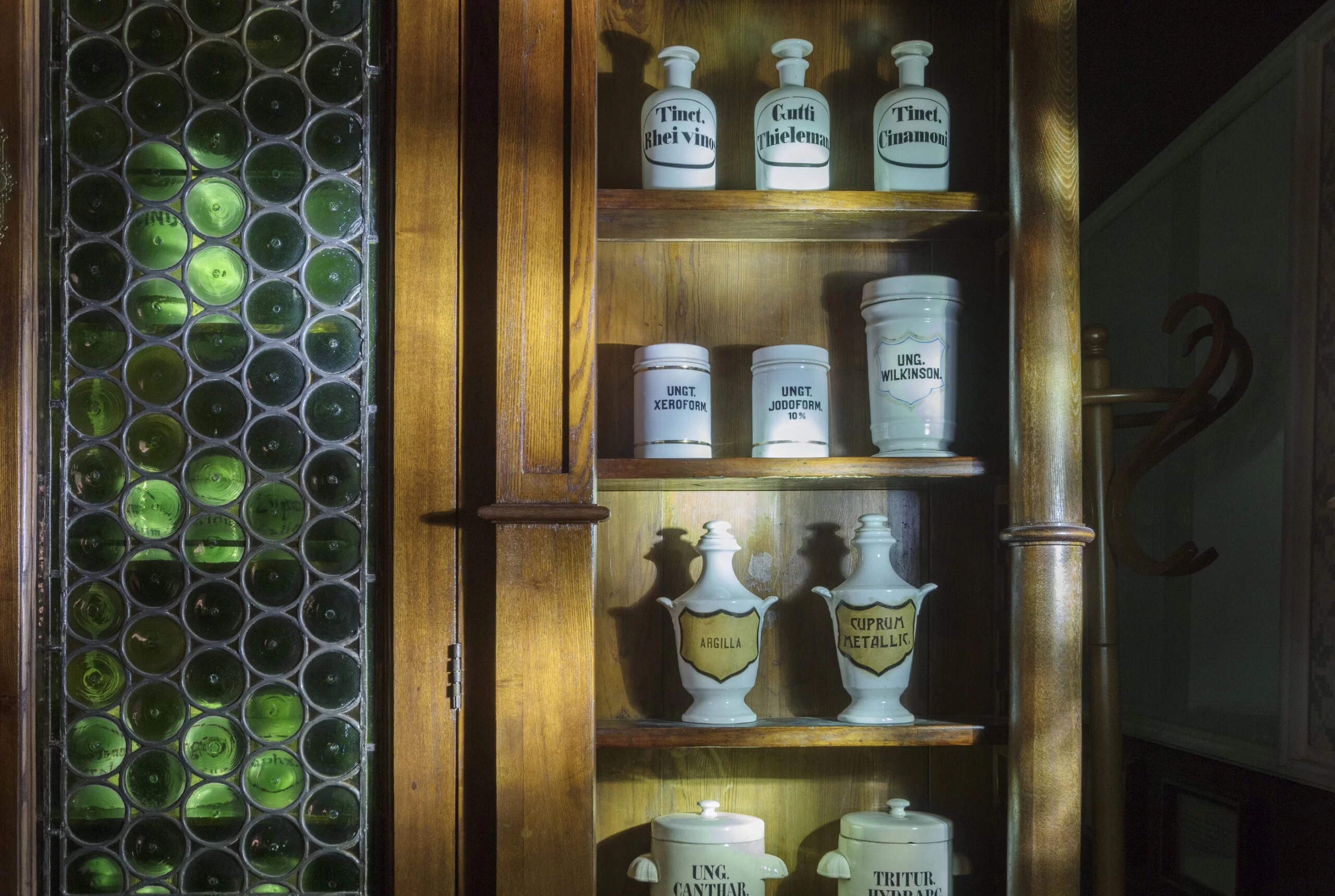 Close-up of cabinet showing several jars of medicinal preparations. The names of the preparations can be seen on the jars, in historical fonts.