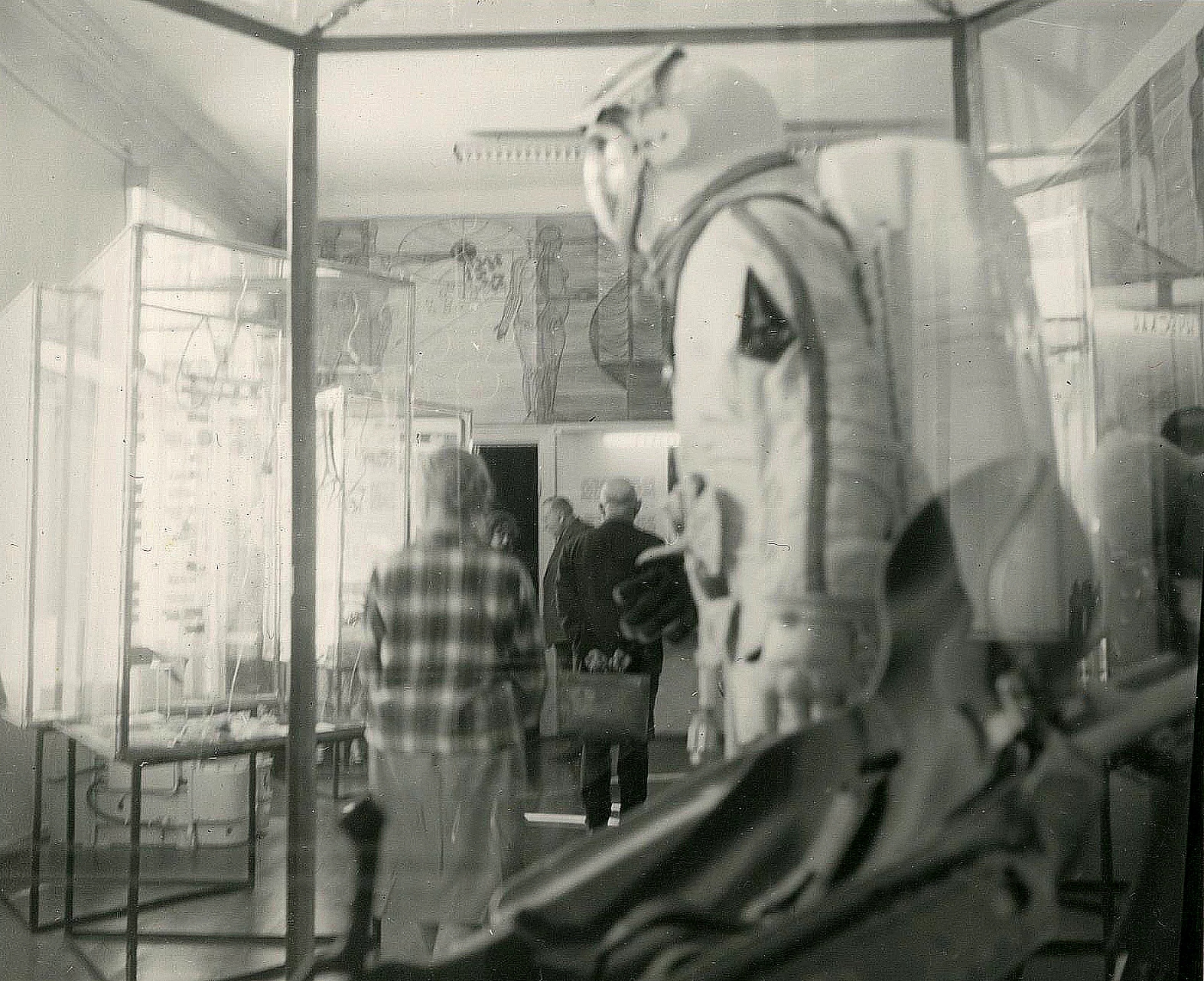 In the foreground is a mannequin in an astronaut suit. Various other exhibits are visible in the background and an illustration with anatomical motifs is on the wall.
