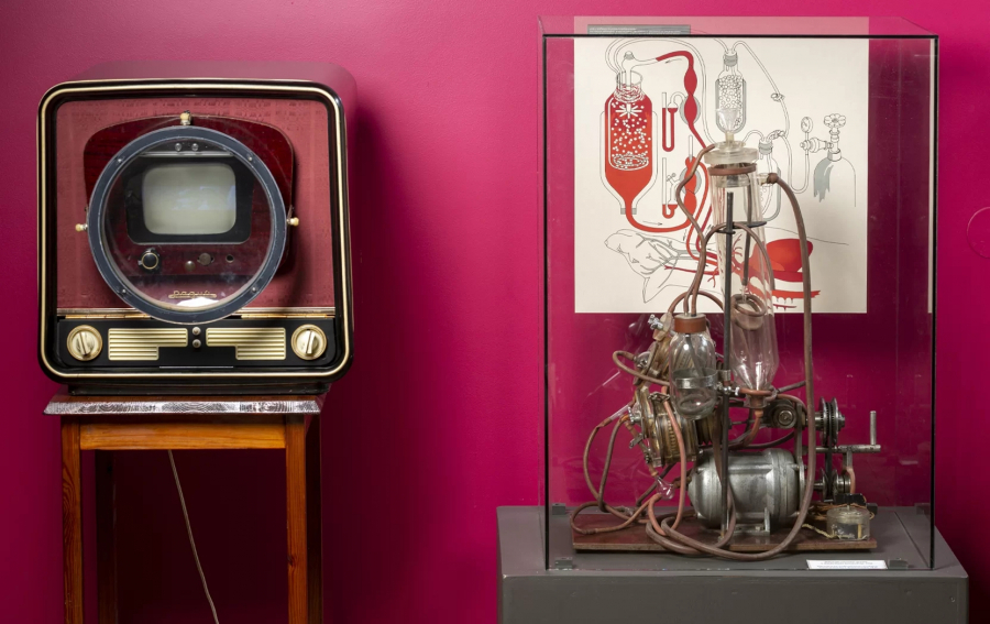 An old television with a small screen and a magnifying glass and an artificial blood circulation machine from the 1930s