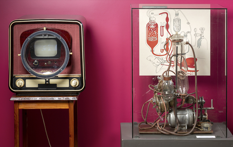 A photo from the museum exhibit with a historic television set next to an artificial blood circulation machine.